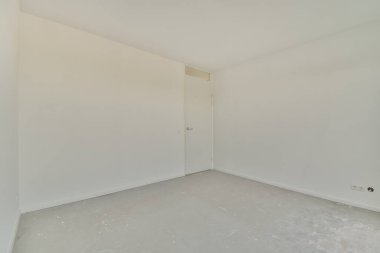 Evdeki boş ışık odasında, beyaz duvardaki plastik pencere ve radyatör.