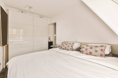 Yatak odasının iç tasarımı, yatak odası ve ahşap gardırop modern dairenin penceresinin kenarına yerleştirilmiş.