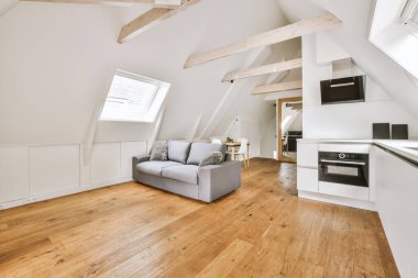 Günümüz minimalist tasarımı. Hafif stüdyo dairesinin ahşap masası ve oturma odası ile beyaz duvarları ve parke zemini arasında yemek masası ve sandalyeleri var.