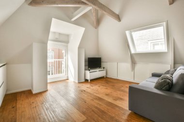 Günümüz minimalist tasarımı. Hafif stüdyo dairesinin ahşap masası ve oturma odası ile beyaz duvarları ve parke zemini arasında yemek masası ve sandalyeleri var.