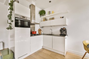 Mutfağın yakınındaki açık oturma odasında zarif avizenin altında yumuşak yastıklı büyük bir kanepe.