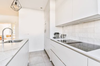 Geniş, hafif yemek odasının içi. Mutfağın yanında güzel bir avize ve rahat mobilyalar var.