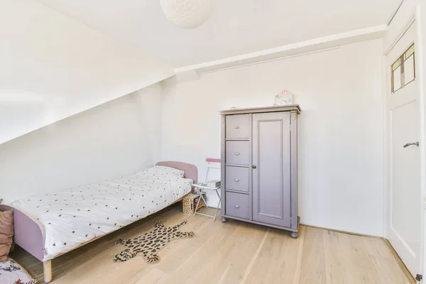 Interior of modern kid bedroom with bed and shelves with various toys at home