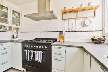 Minimalist tarzı beyaz mobilyalı, lavabolu ve sobalı bir ev mutfağı.