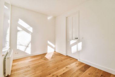 Evdeki boş ışık odasında, beyaz duvardaki plastik pencere ve radyatör.