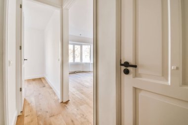 Evdeki boş ışık odasında, beyaz duvardaki plastik pencere ve radyatör.