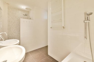 Aynalı lavabo ve temiz küvet modern banyoda cam kapılı ve beyaz fayanslı duvarları olan duş kutusunun yanında.