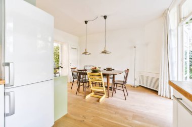 Minimalist tarzı açık mutfağı ve masa ve sandalyeleri olan geniş yemek alanı olan modern çatı katı dairesinin ev tasarımı.