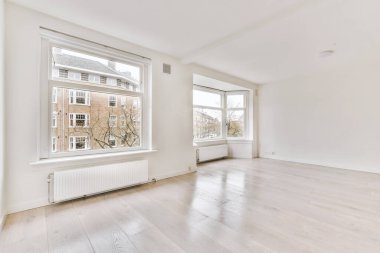 Evdeki boş ışık odasında, beyaz duvardaki plastik pencere ve radyatör.