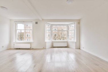 Evdeki boş ışık odasında, beyaz duvardaki plastik pencere ve radyatör.