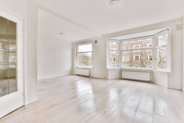 Evdeki boş ışık odasında, beyaz duvardaki plastik pencere ve radyatör.