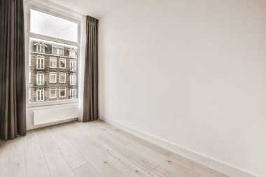 Pencereleri ve ahşap parke zemini olan boş beyaz mutfağın içi.