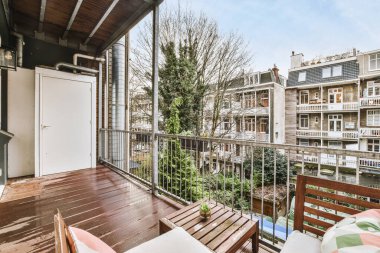 Parmaklıklı küçük balkondan eski binaların önü.