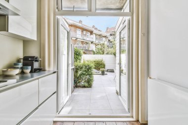 Minimalist tarzı beyaz mobilyalı, lavabolu ve sobalı bir ev mutfağı.