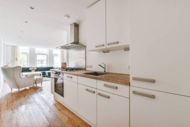 Minimalist tarzı beyaz mobilyalı, lavabolu ve sobalı bir ev mutfağı.