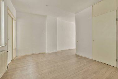 Evdeki boş ışık odasında, beyaz duvardaki plastik pencere ve radyatör.