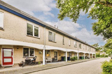 Arabaları, ağaçları ve fenerleri olan boş bir kaldırımdan panorama manzaralı evler.