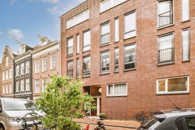 Arabaları, ağaçları ve fenerleri olan boş bir kaldırımdan panorama manzaralı evler.