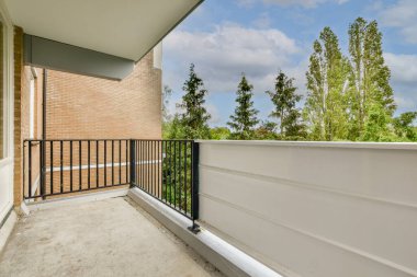 Narrow brick balcony with metal railings and door