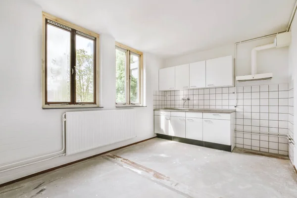 带有窗户和木制地板的空的白色厨房的内部 — 图库照片