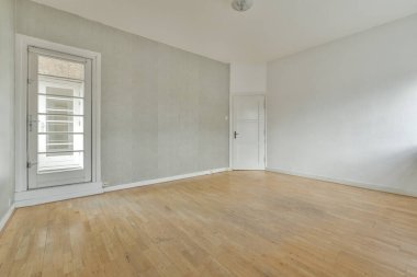 Evdeki boş ışık odasında, beyaz duvardaki plastik pencere ve radyatör.