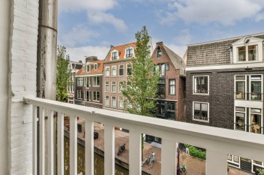Front view of new brick buildings and cars with bicycles from small balcony with railings