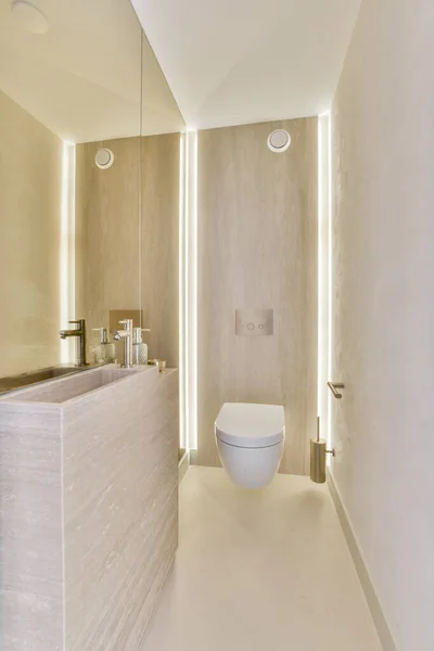 Interior of contemporary bathroom with shabby beige walls and partitions and white door at home