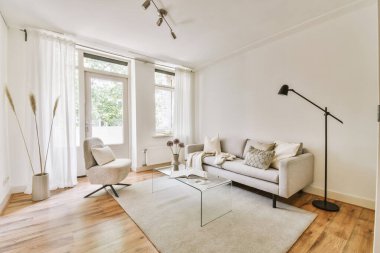 Günümüz minimalist tasarımı. Hafif stüdyo dairesinin ahşap masası ve oturma odası ile beyaz duvarları ve parke zemini arasında yemek masası ve sandalyeleri var.