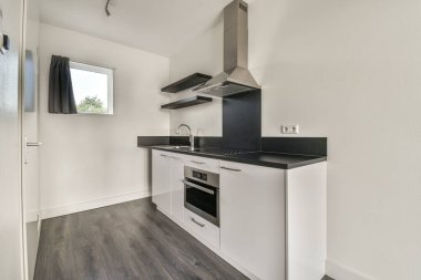 Interior of empty white kitchen with corridor and wooden parquet floor