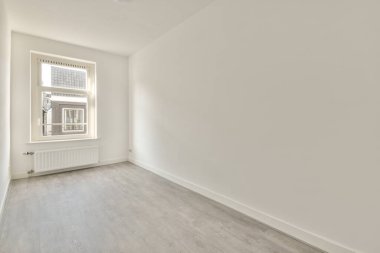 Evdeki boş ışık odasında, beyaz duvardaki plastik pencere ve radyatör.