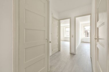 Koridoru ve ahşap parke zemini olan boş beyaz mutfağın içi.