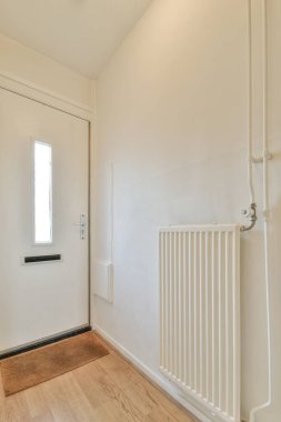 Beyaz duvarları ve aynalı gardırobu ve minimalist tarzda parke zemini olan boş dar koridor manzarası.