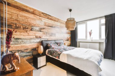 Yatak odasının iç tasarımı, yatak odası ve ahşap gardırop modern dairenin penceresinin kenarına yerleştirilmiş.