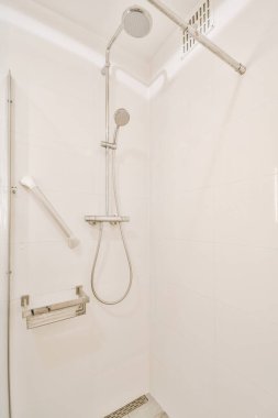 Duş muslukları cam bölmenin yanındaki fayanslı duvara bağlı ve evdeki tuvaletteki süs pervazı.