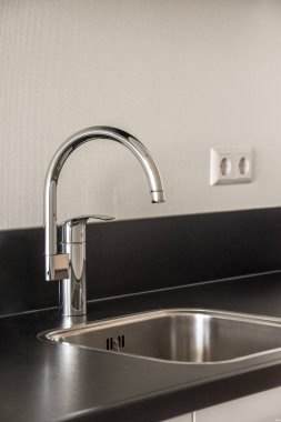 Pencereleri ve ahşap parke zemini olan boş beyaz mutfağın içi.