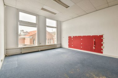 Büyük balkon pencereli, perdeli ve ahşap parke zeminli boş beyaz odanın içi.