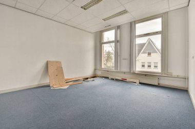 Büyük balkon pencereli, perdeli ve ahşap parke zeminli boş beyaz odanın içi.