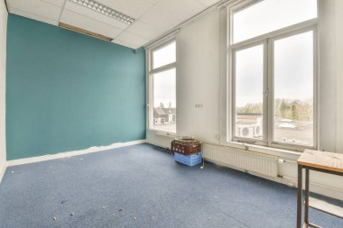 Büyük balkon pencereli, perdeli ve ahşap parke zeminli boş beyaz odanın içi.