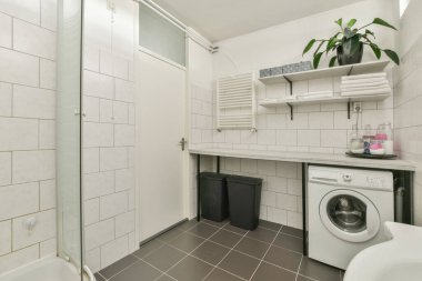 Tuvaleti duvara asılmış beyaz fayanslı banyoda lavabo ve ayna dolabı.