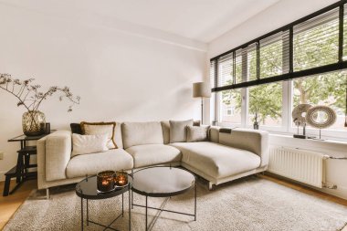 Contemporary minimalist style interior design of light studio apartment with wooden table and chairs in dining zone in living room with white walls and parquet floor