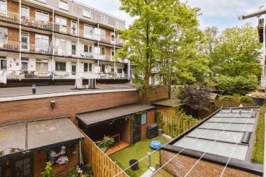 Oturma alanı ve ahşap çitlerin yanındaki küçük bahçesi olan düzgün asfaltlı bir avlu.