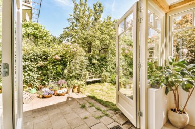 Neat paved patio with sitting area and small garden near wooden fence