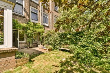 Oturma alanı ve ahşap çitlerin yanındaki küçük bahçesi olan düzgün asfaltlı bir avlu.