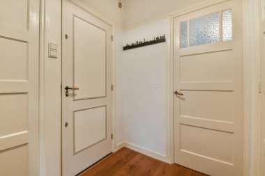 Şık bir oturma odası, rahat bir kanepe ve modern bir dairede masanın etrafına yerleştirilmiş yastıklı koltuklar.