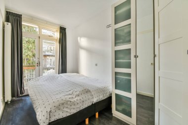 Yatak odasının iç tasarımı, yatak odası ve ahşap gardırop modern dairenin penceresinin kenarına yerleştirilmiş.