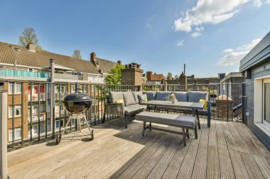 Oturma alanı ve ahşap çitlerin yanındaki küçük bahçesi olan düzgün asfaltlı bir avlu.