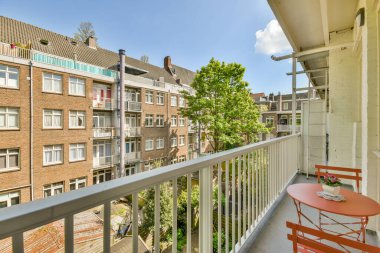 Eski tuğlalı binaların ve bisikletli arabaların ön manzarası küçük balkondan tırabzanlara kadar uzanıyor.