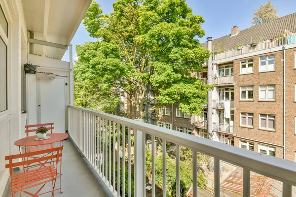 Eski tuğlalı binaların ve bisikletli arabaların ön manzarası küçük balkondan tırabzanlara kadar uzanıyor.