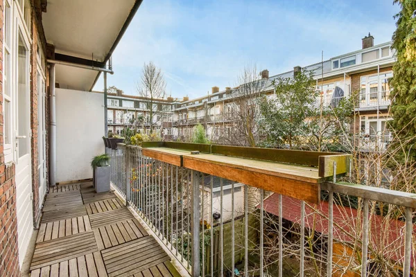 Eski tuğlalı binaların ve bisikletli arabaların ön manzarası küçük balkondan tırabzanlara kadar uzanıyor.