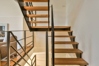 Beyaz spiral merdiven, çağdaş evi ahşap zemin ve beyaz duvarlarla birbirine bağlıyor.